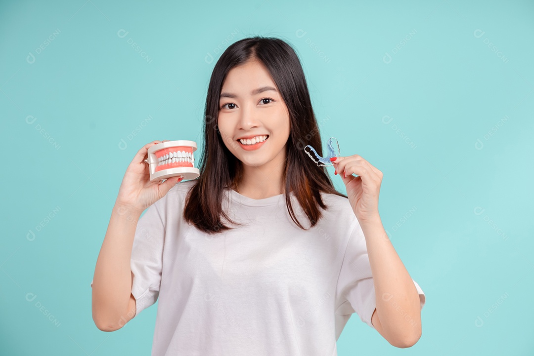 Sorriso bonito dental da jovem mulher asiática com aparelho retentor