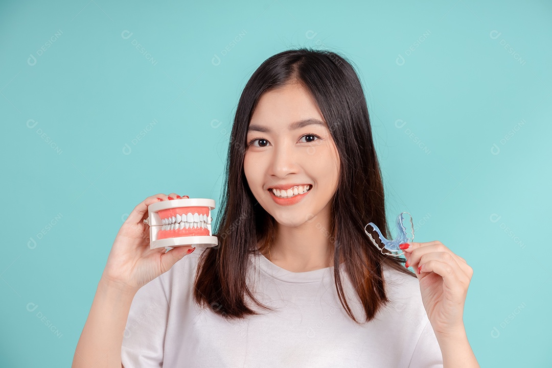 Sorriso bonito dental da jovem mulher asiática com aparelho retentor