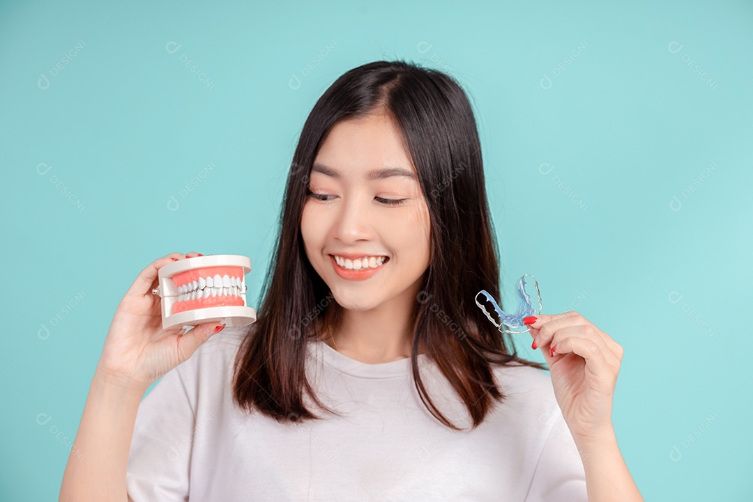 Sorriso bonito dental da jovem mulher asiática com aparelho retentor