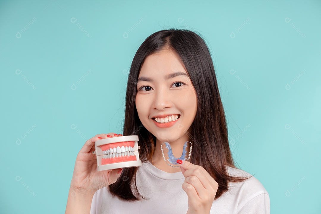 Sorriso bonito dental da jovem mulher asiática com aparelho retentor