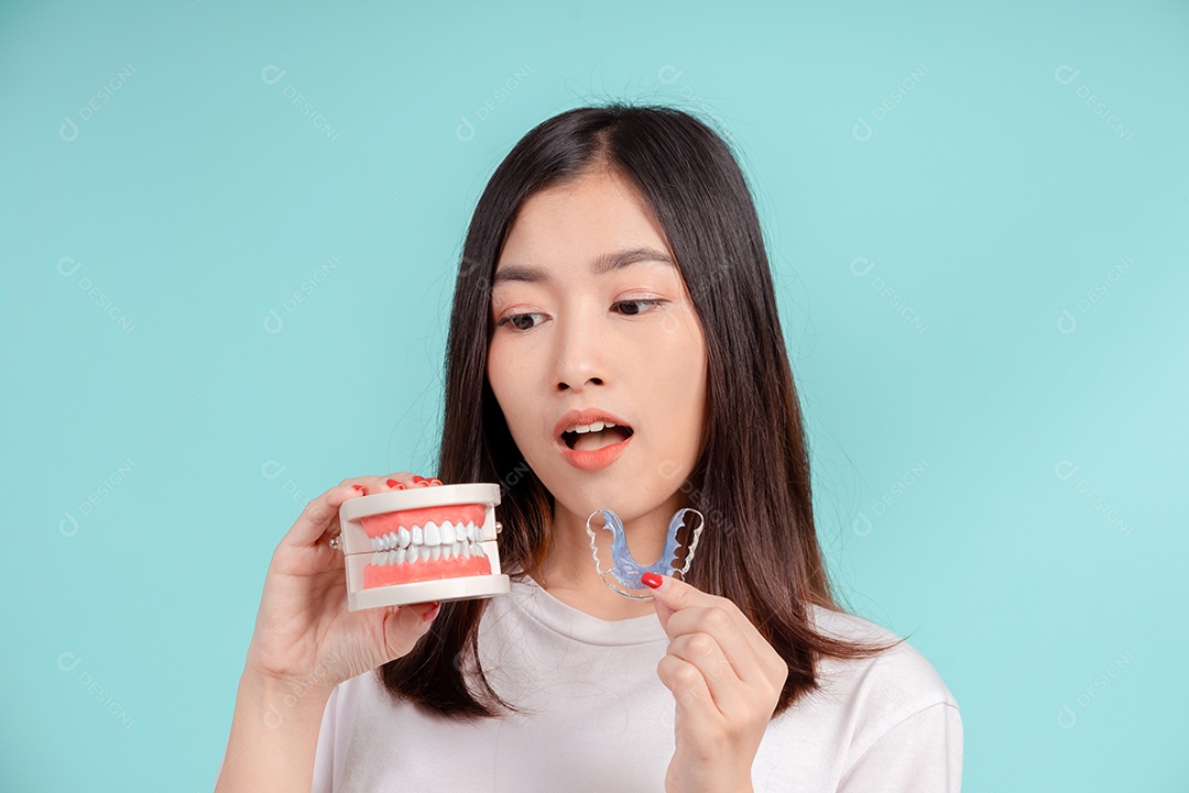 Sorriso bonito dental da jovem mulher asiática com aparelho retentor