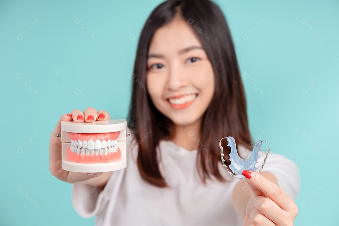 Sorriso bonito dental da jovem mulher asiática com aparelho retentor