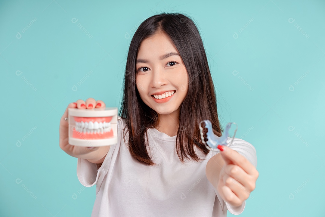 Sorriso bonito dental da jovem mulher asiática com aparelho retentor