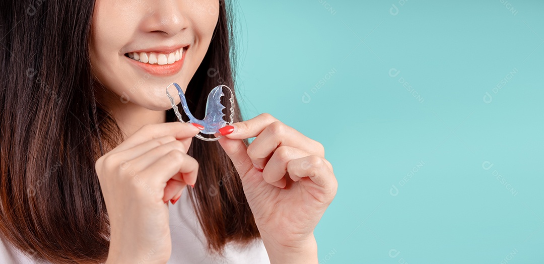 Sorriso bonito dental da jovem mulher asiática com aparelho retentor