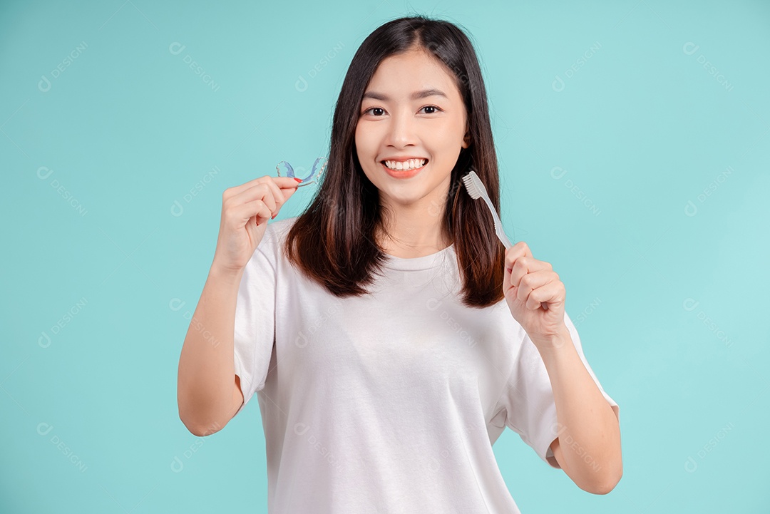 Sorriso bonito dental da jovem mulher asiática com aparelho retentor