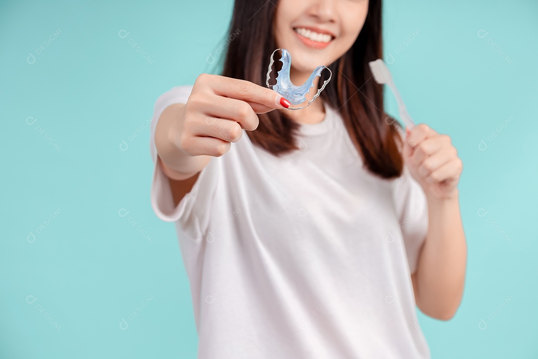 Sorriso bonito dental da jovem mulher asiática com aparelho retentor