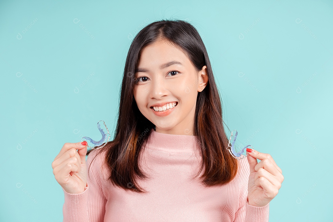 Sorriso bonito dental da jovem mulher asiática com aparelho retentor