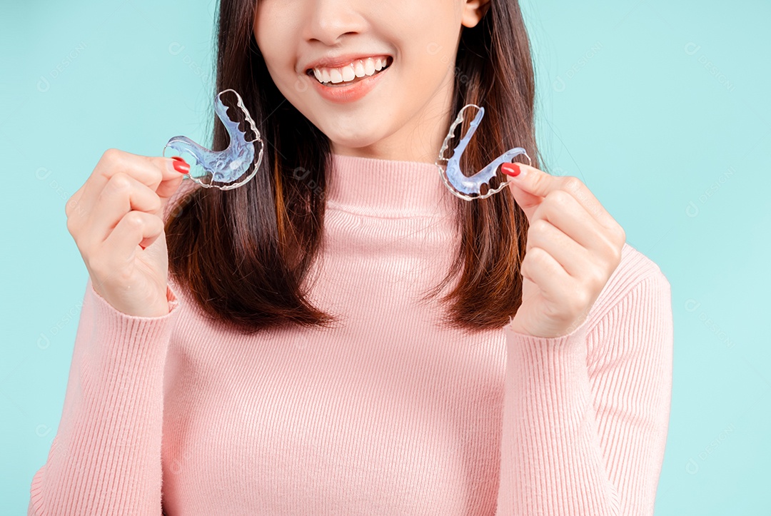 Sorriso bonito dental da jovem mulher asiática com aparelho retentor