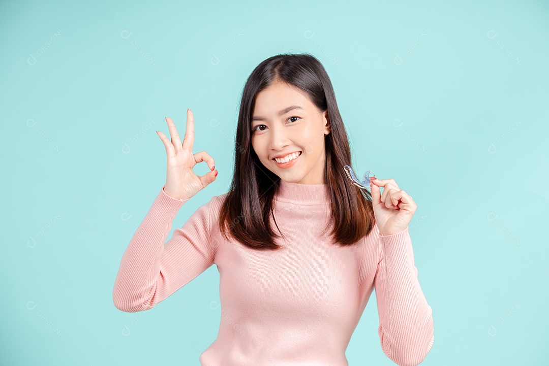 Sorriso bonito dental da jovem mulher asiática com aparelho retentor