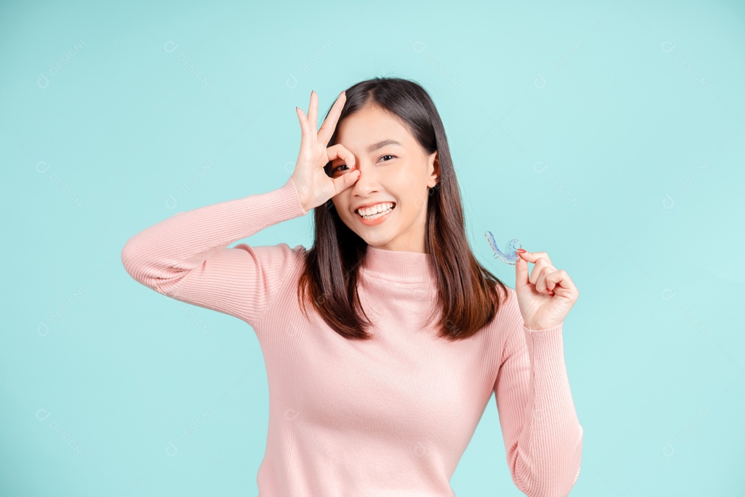 Sorriso bonito dental da jovem mulher asiática com aparelho retentor