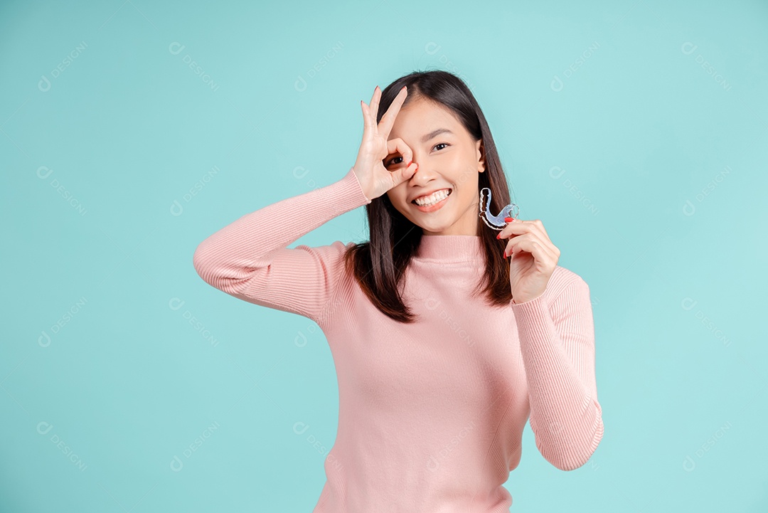 Sorriso bonito dental da jovem mulher asiática com aparelho retentor