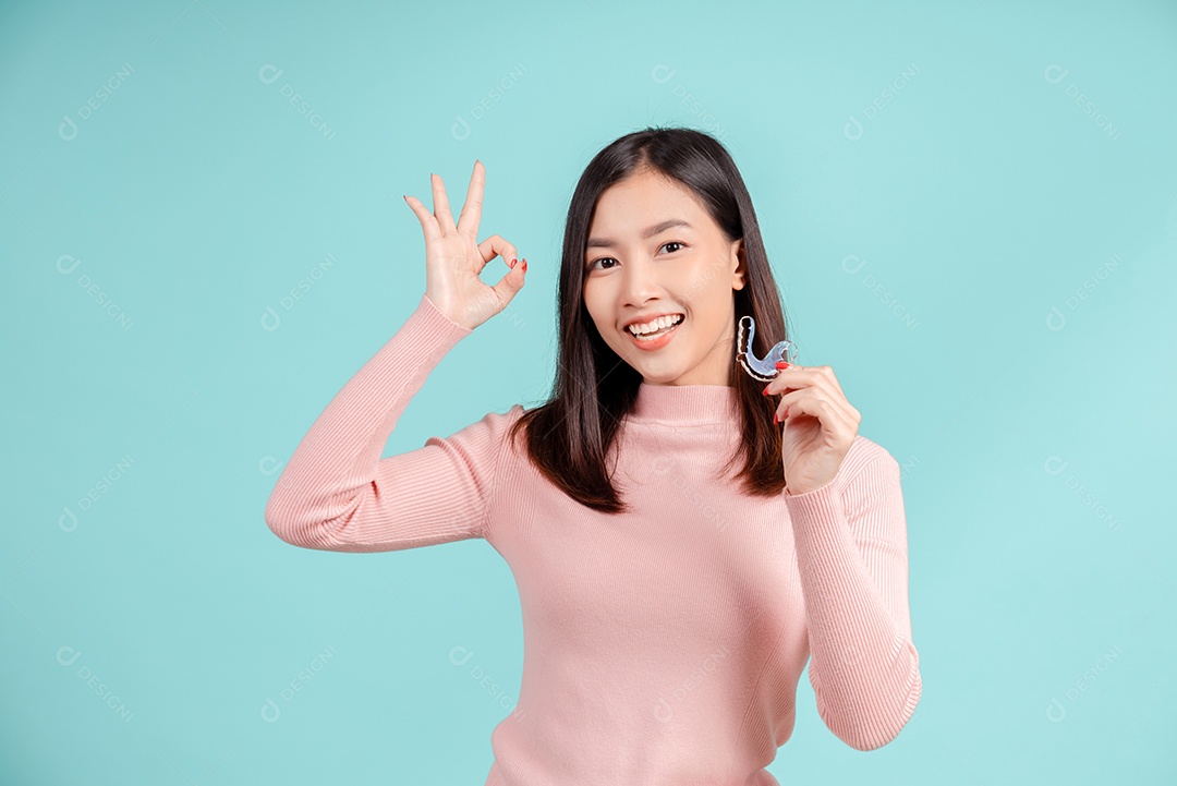 Sorriso bonito dental da jovem mulher asiática com aparelho retentor