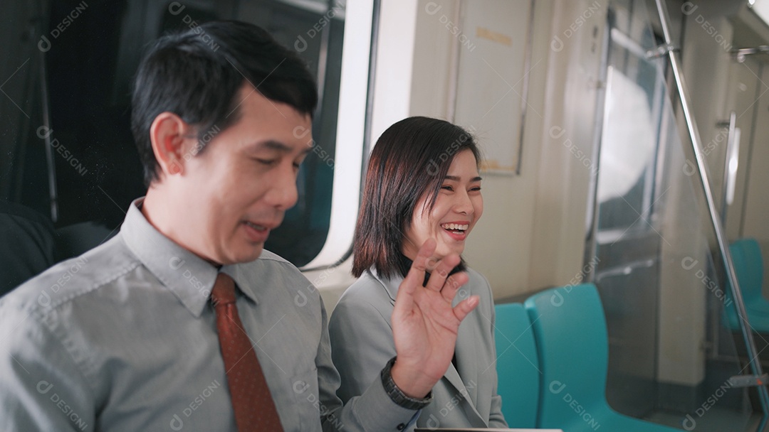 Empresário asiático conversando com empresária no skytrain ou metrô