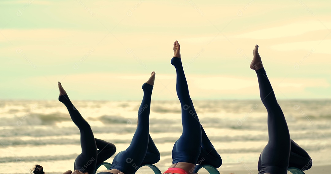 Mulheres que praticam yoga em grupo em aula no exercício de relaxamento de alongamento