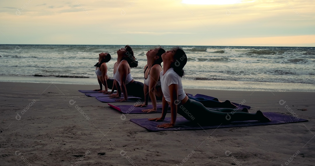 Mulheres que praticam yoga em grupo em aula no exercício de relaxamento de alongamento