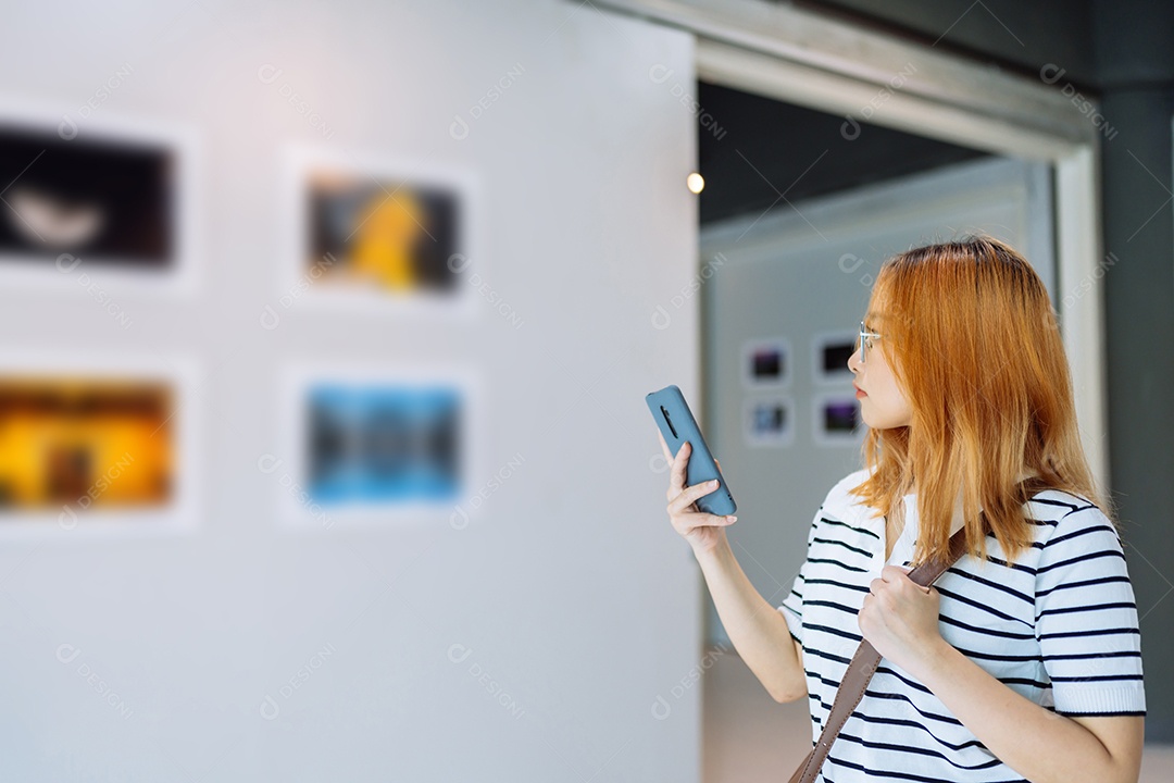 Mulher visitando a galeria de arte suas fotos olhando na parede, observando quadro