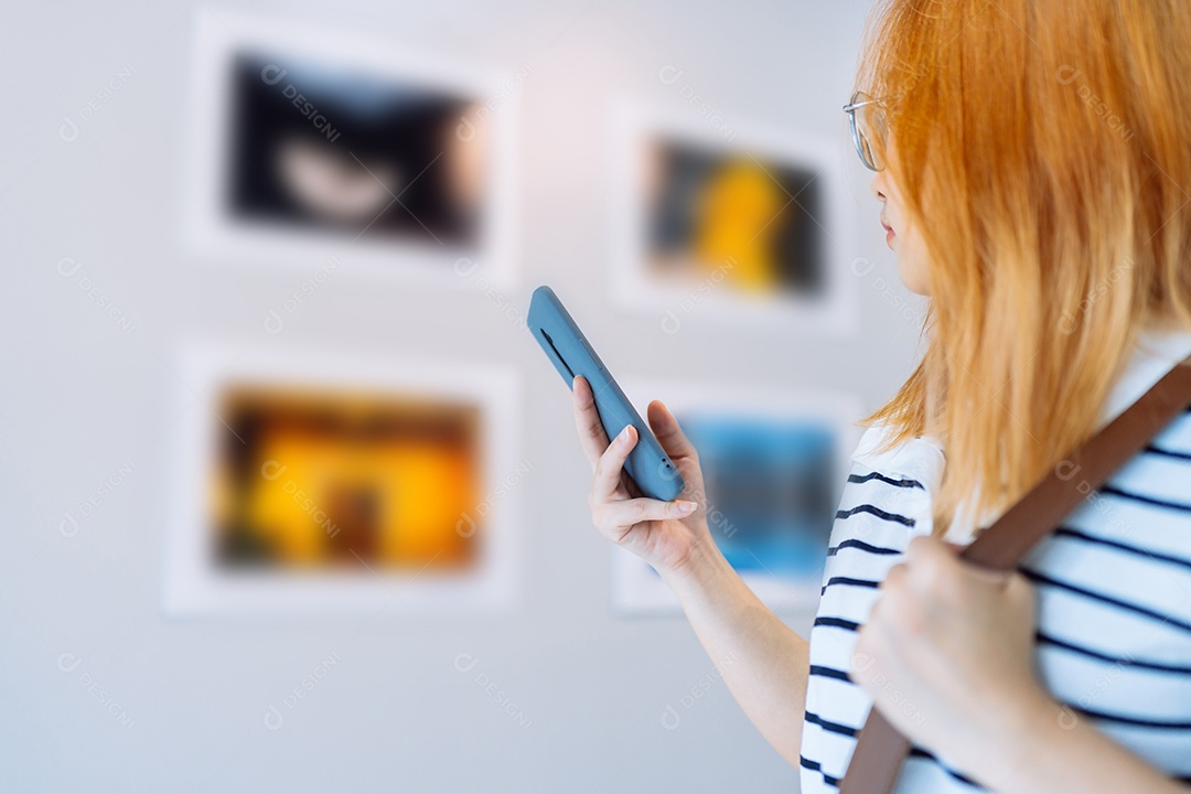 Mulher visitando a galeria de arte suas fotos olhando na parede, observando quadro