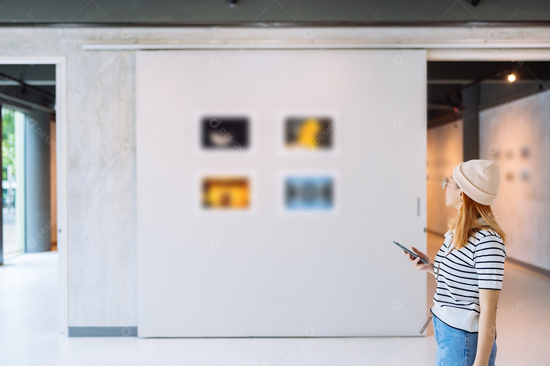 Mulher visitando a galeria de arte suas fotos olhando na parede, observando quadro