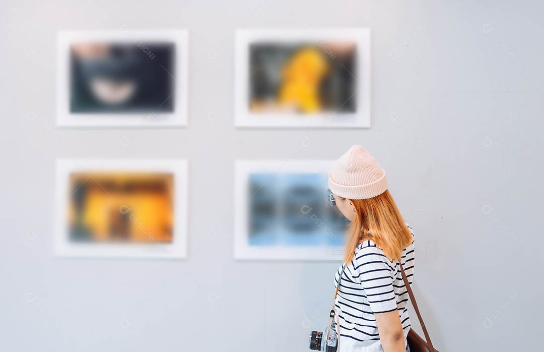 Mulher visitando a galeria de arte suas fotos olhando na parede, observando quadro