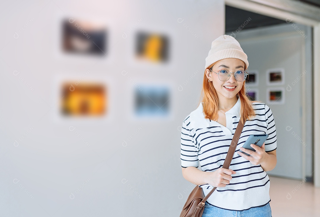Mulher visitando a galeria de arte suas fotos olhando na parede, observando quadro
