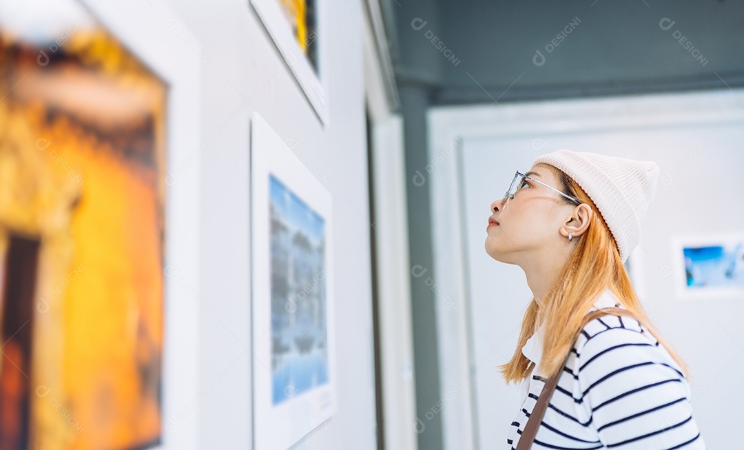 Mulher visitando a galeria de arte, observando obras