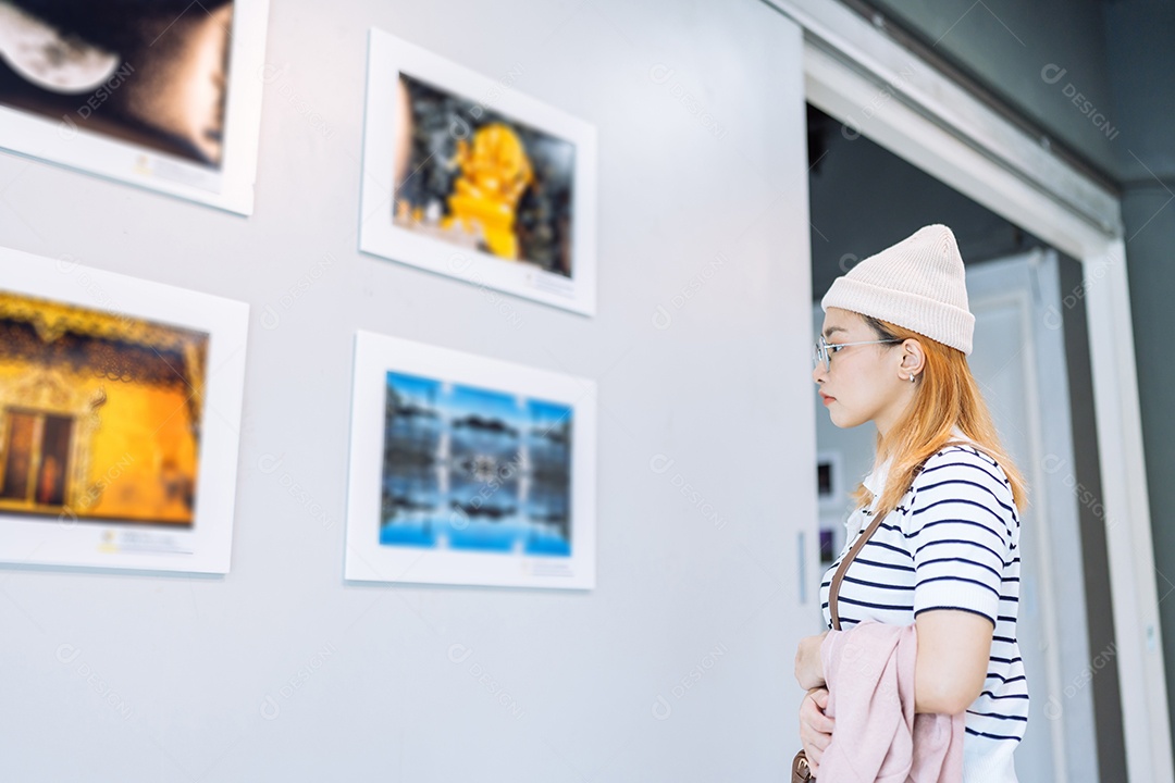 Mulher visitando a galeria de arte, observando obras