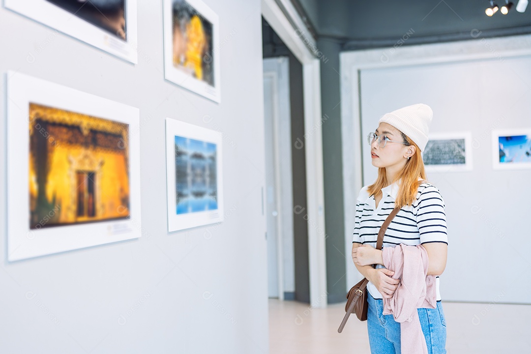 Mulher visitando a galeria de arte, observando obras