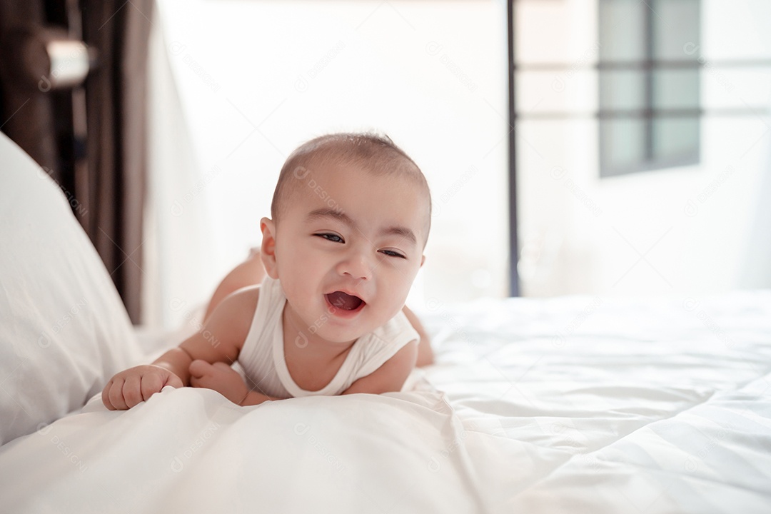 Bebê recém-nascido deitado em uma cama branca em casa.