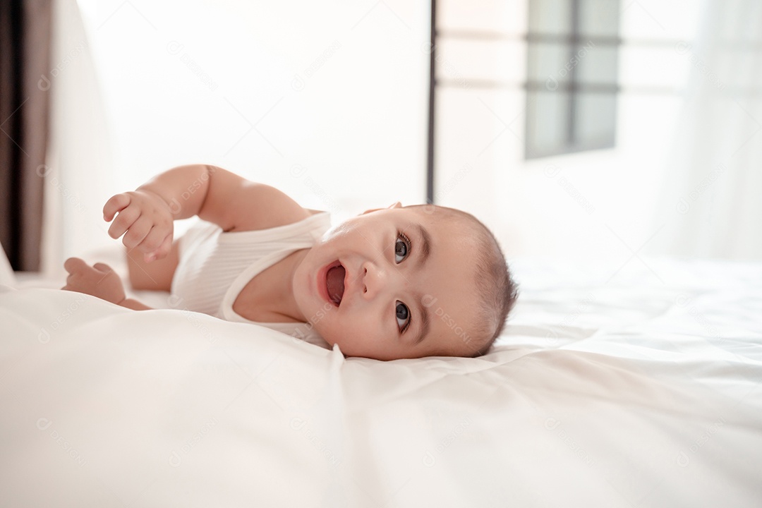 Bebê recém-nascido deitado em uma cama branca em casa.