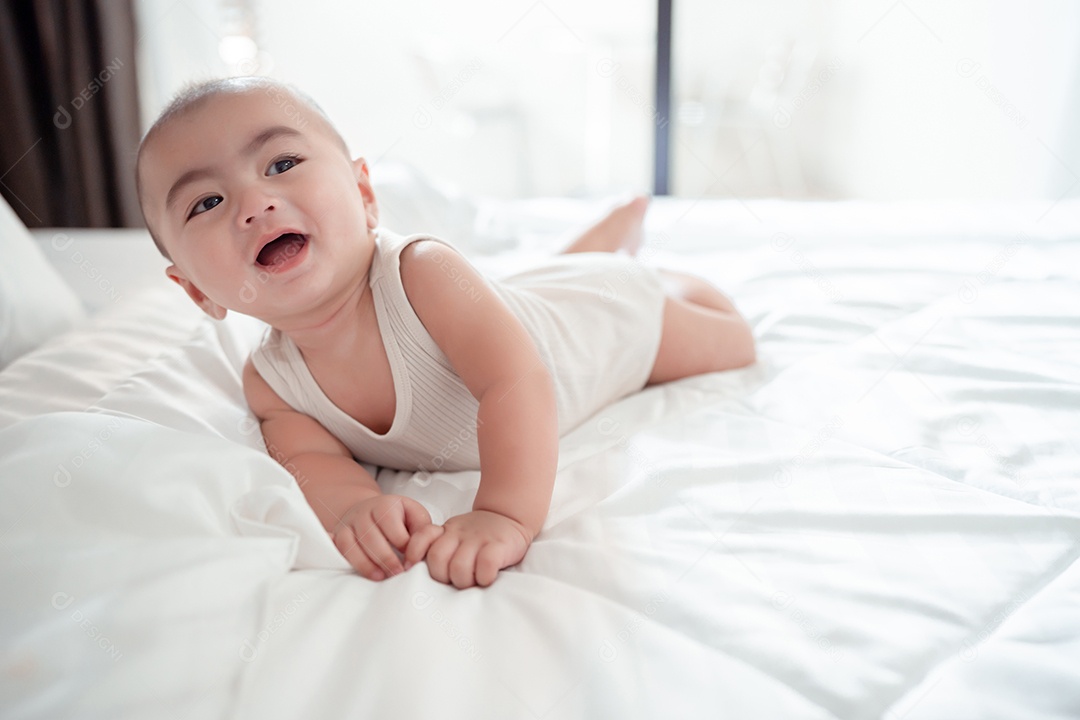 Bebê recém-nascido deitado em uma cama branca em casa.