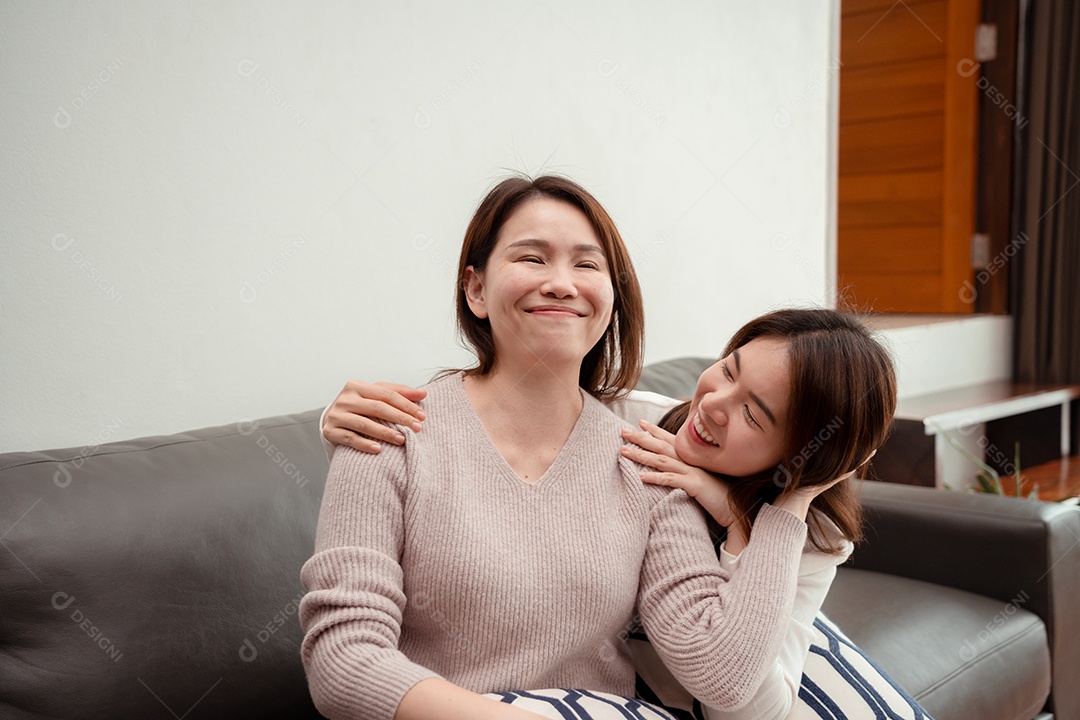 Filha asiática massageando mãe de meia-idade para relaxar