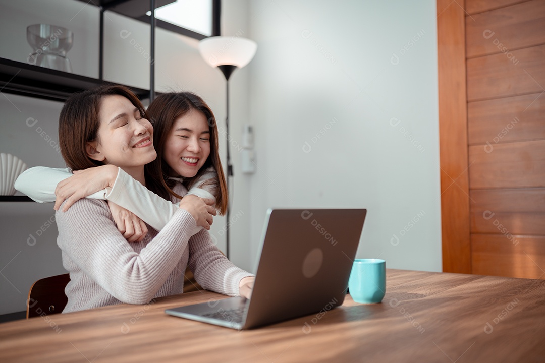 Família asiática, mãe e filha usando laptop juntas