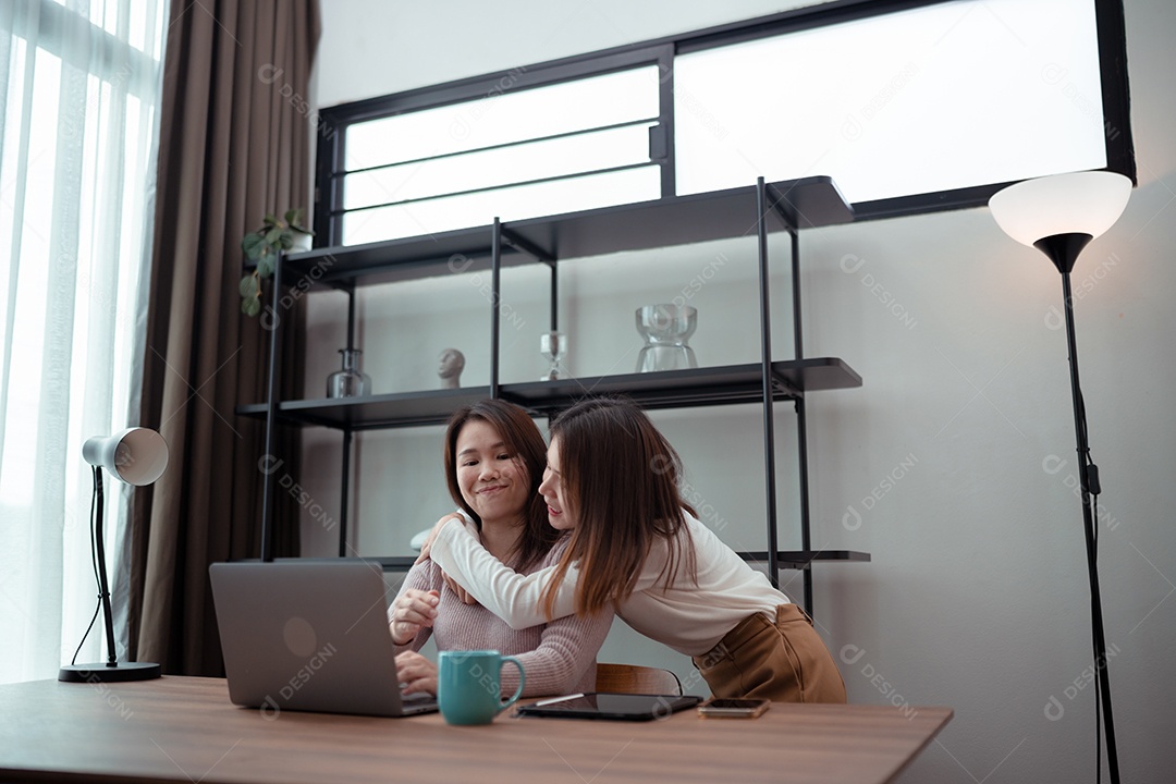 Família asiática, mãe e filha usando laptop juntas