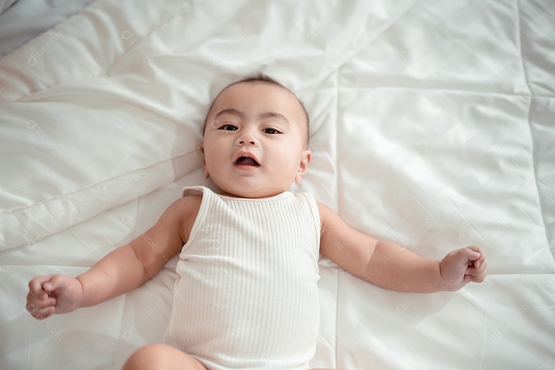 Bebê recém-nascido deitado em uma cama branca em casa.