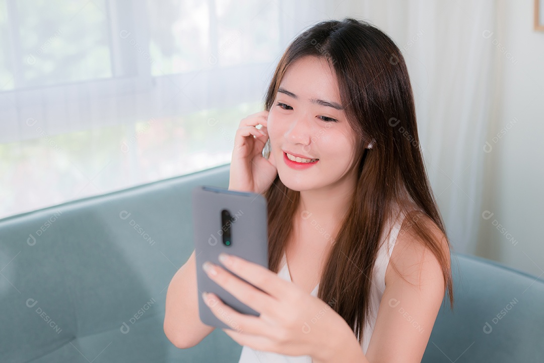 Mulher asiática usa telefone celular para se divertir