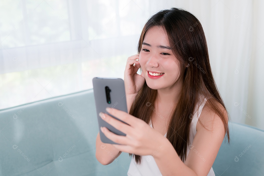 Mulher asiática usa telefone celular para se divertir