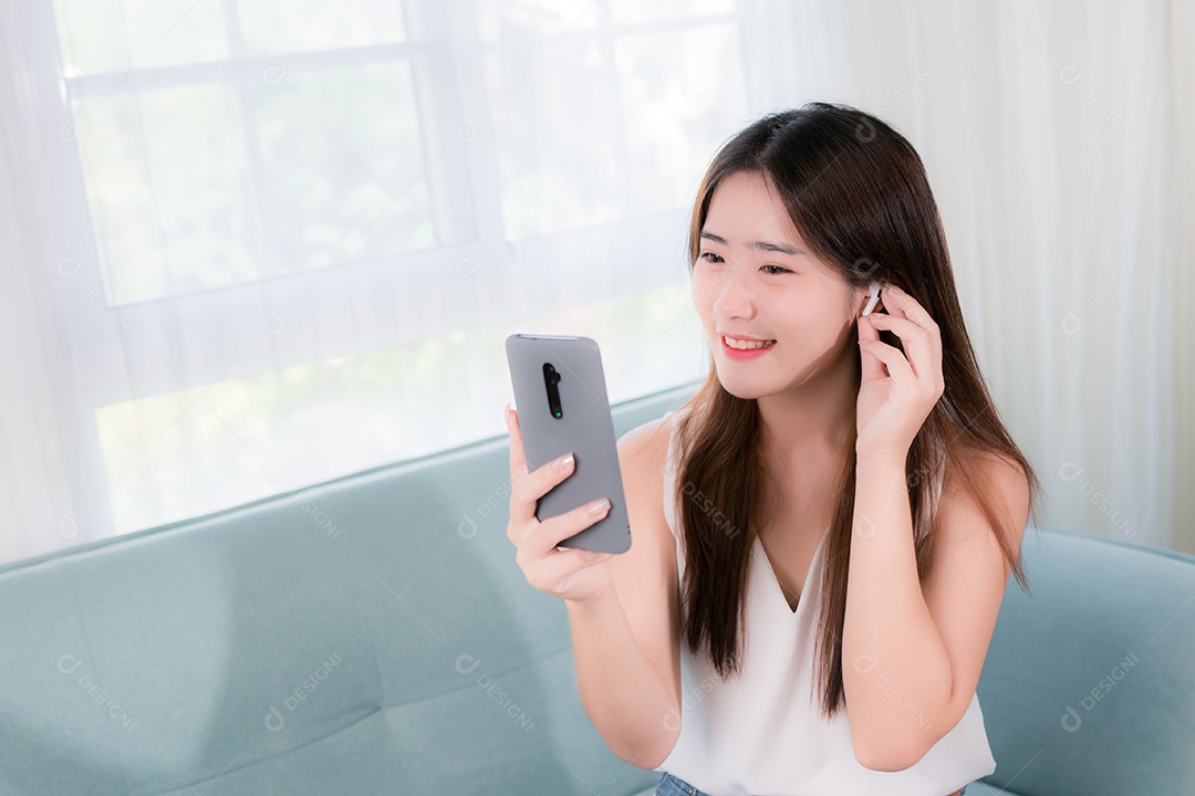 Mulher asiática usa telefone celular para se divertir