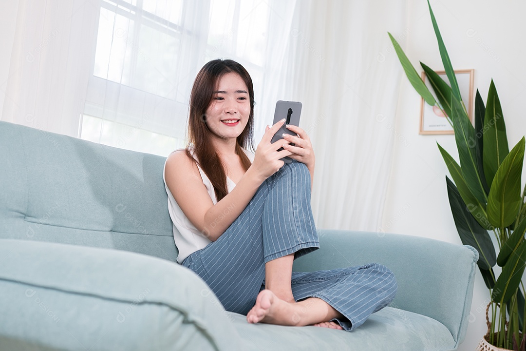 Mulher asiática usa telefone celular para se divertir