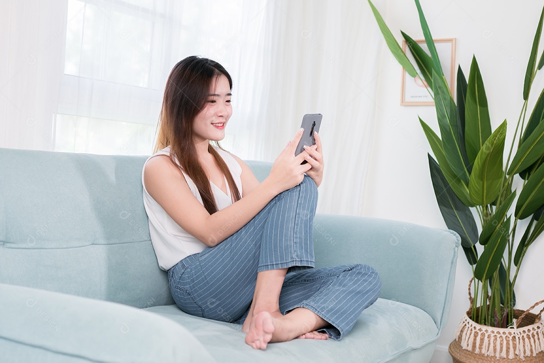 Mulher asiática usa telefone celular para se divertir