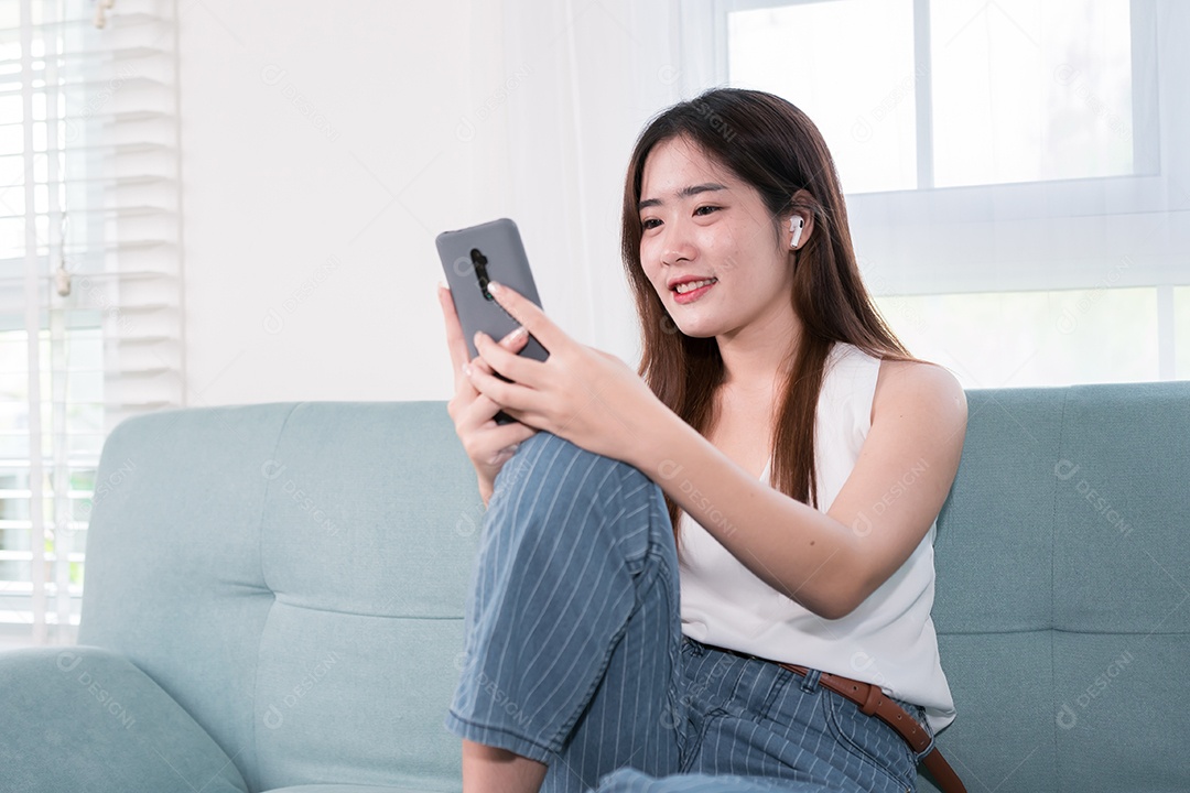 Mulher asiática usa telefone celular para se divertir