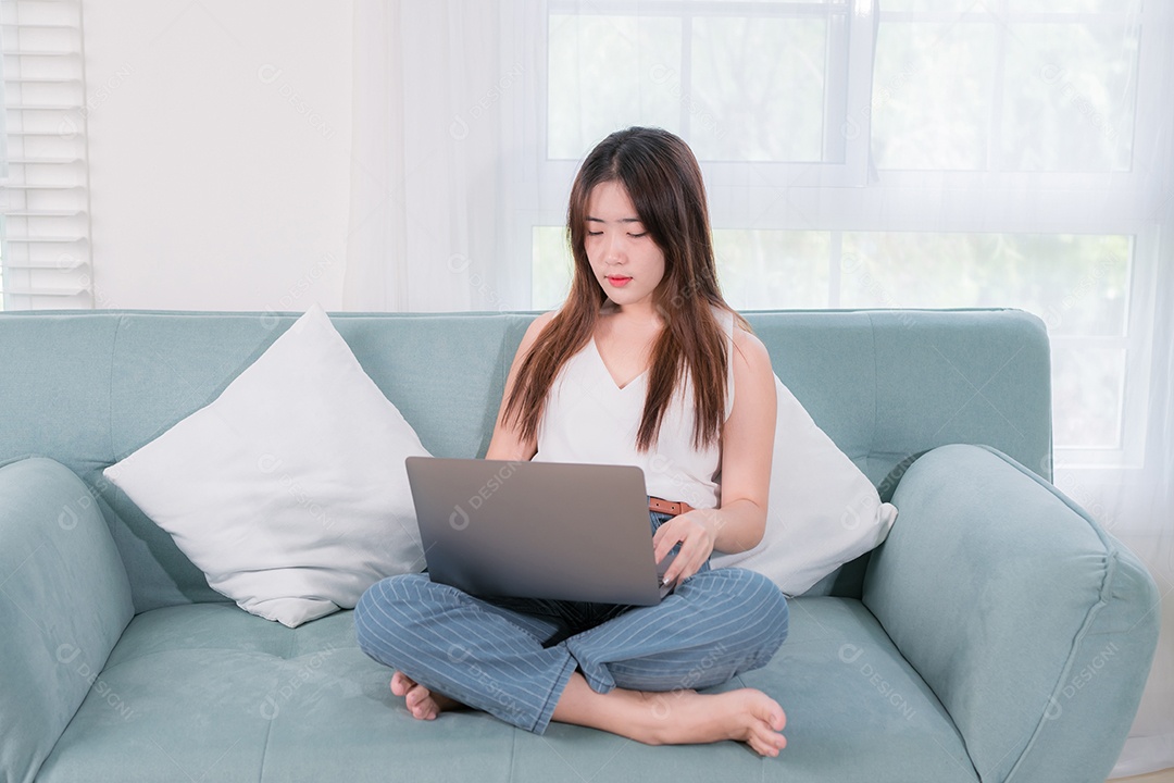 Mulher asiática usa computador portátil para se divertir