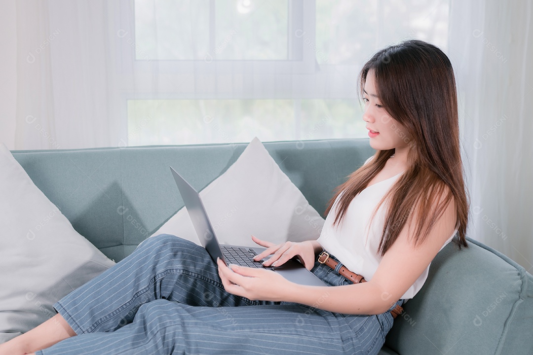 Mulher asiática usa computador portátil para se divertir