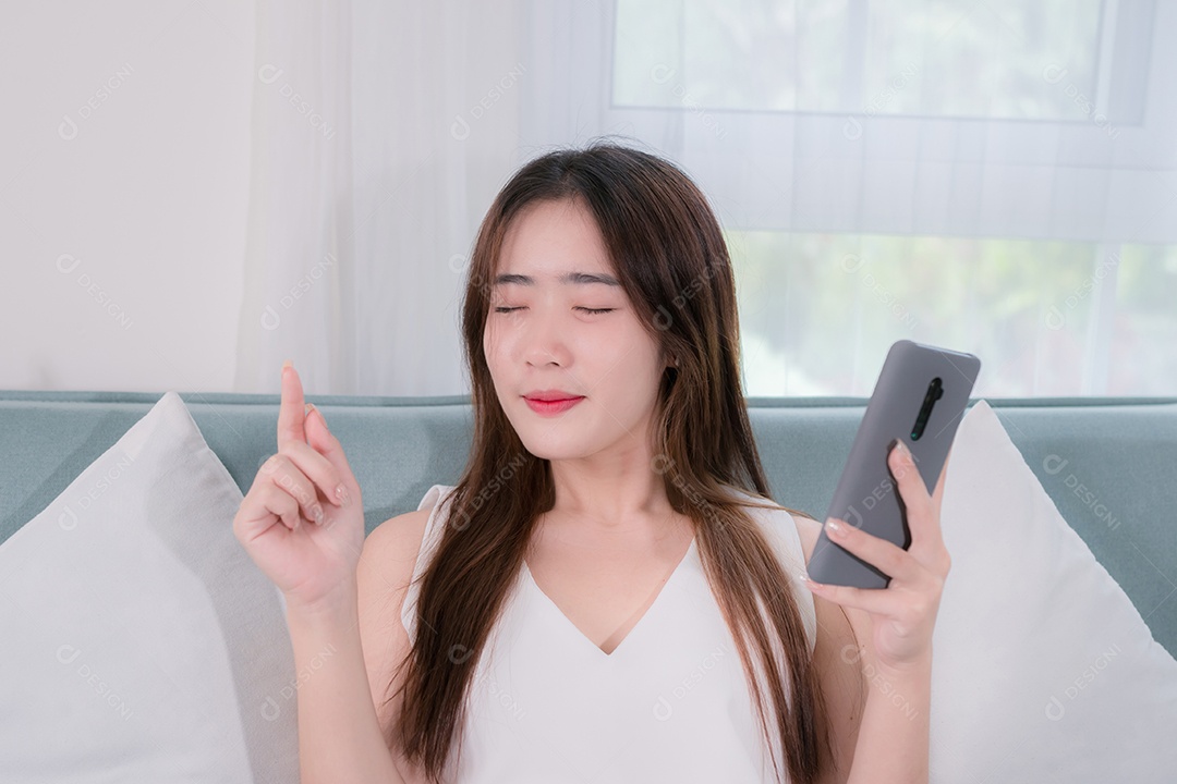 Mulher asiática usa smartphone e usa fones de ouvido