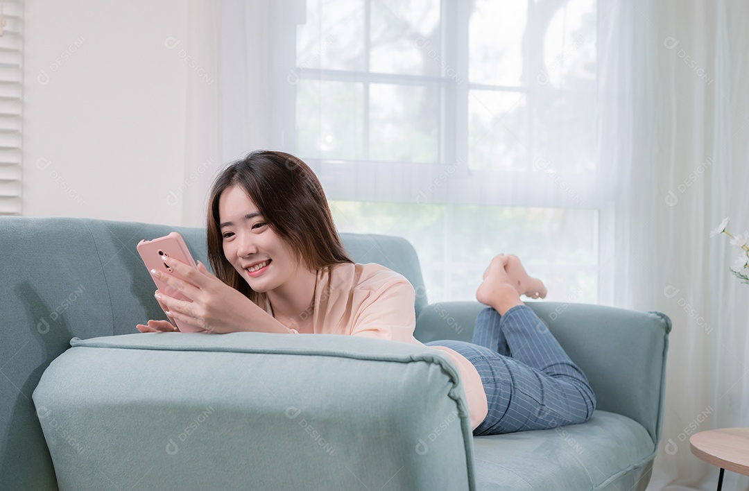 Mulher asiática usa telefone celular para se divertir