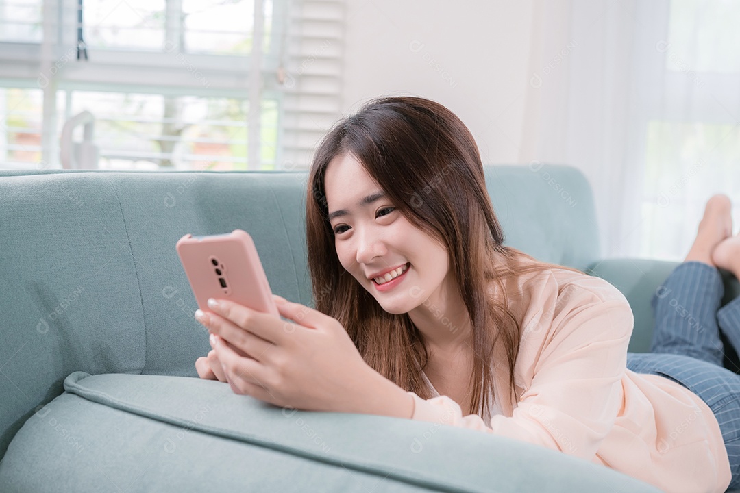 Mulher asiática usa telefone celular para se divertir