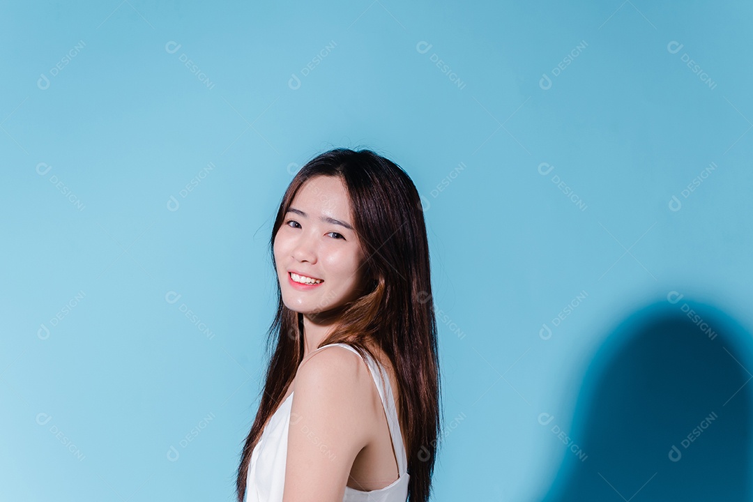 Mulher asiática sorridente modelando em fundo azul