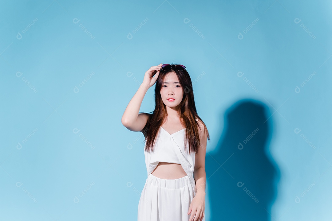 Mulher de beleza asiática encantadora em fundo azul