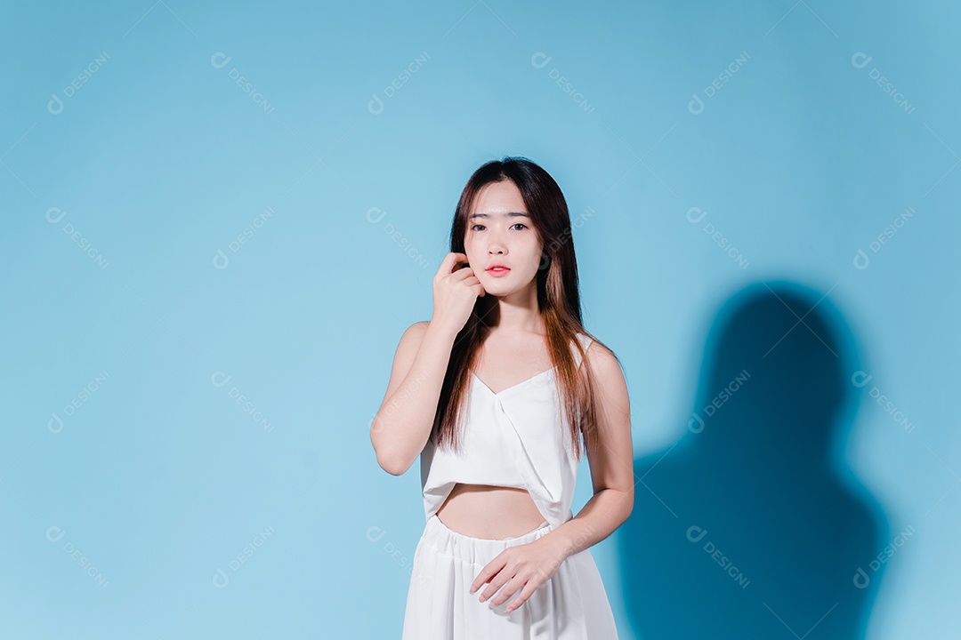 Mulher de beleza asiática encantadora em fundo azul