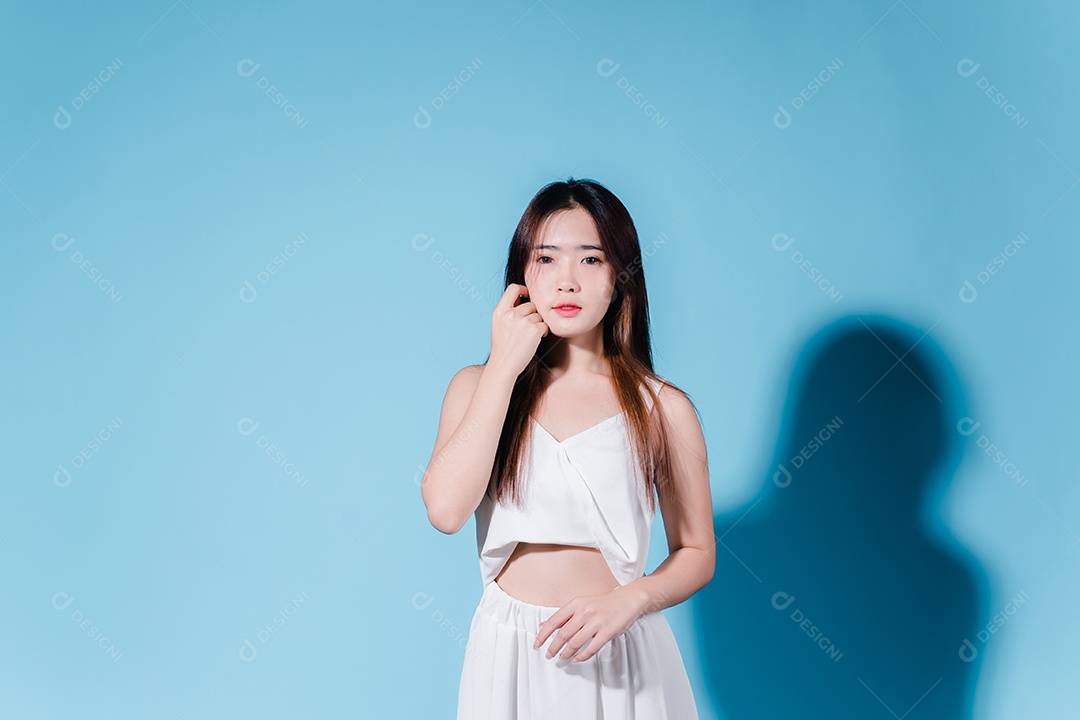 Mulher de beleza asiática encantadora em fundo azul