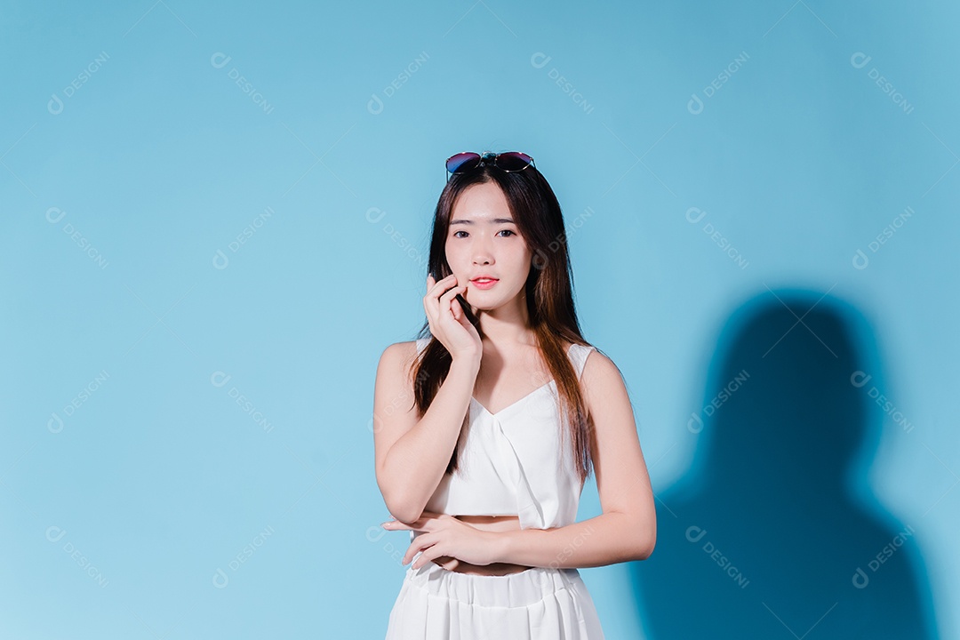 Mulher de beleza asiática encantadora em fundo azul